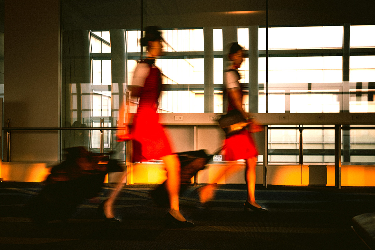 Photo of two flight attendants moving through an airport. Photo by Naitian（Tony） Wang on Unsplash