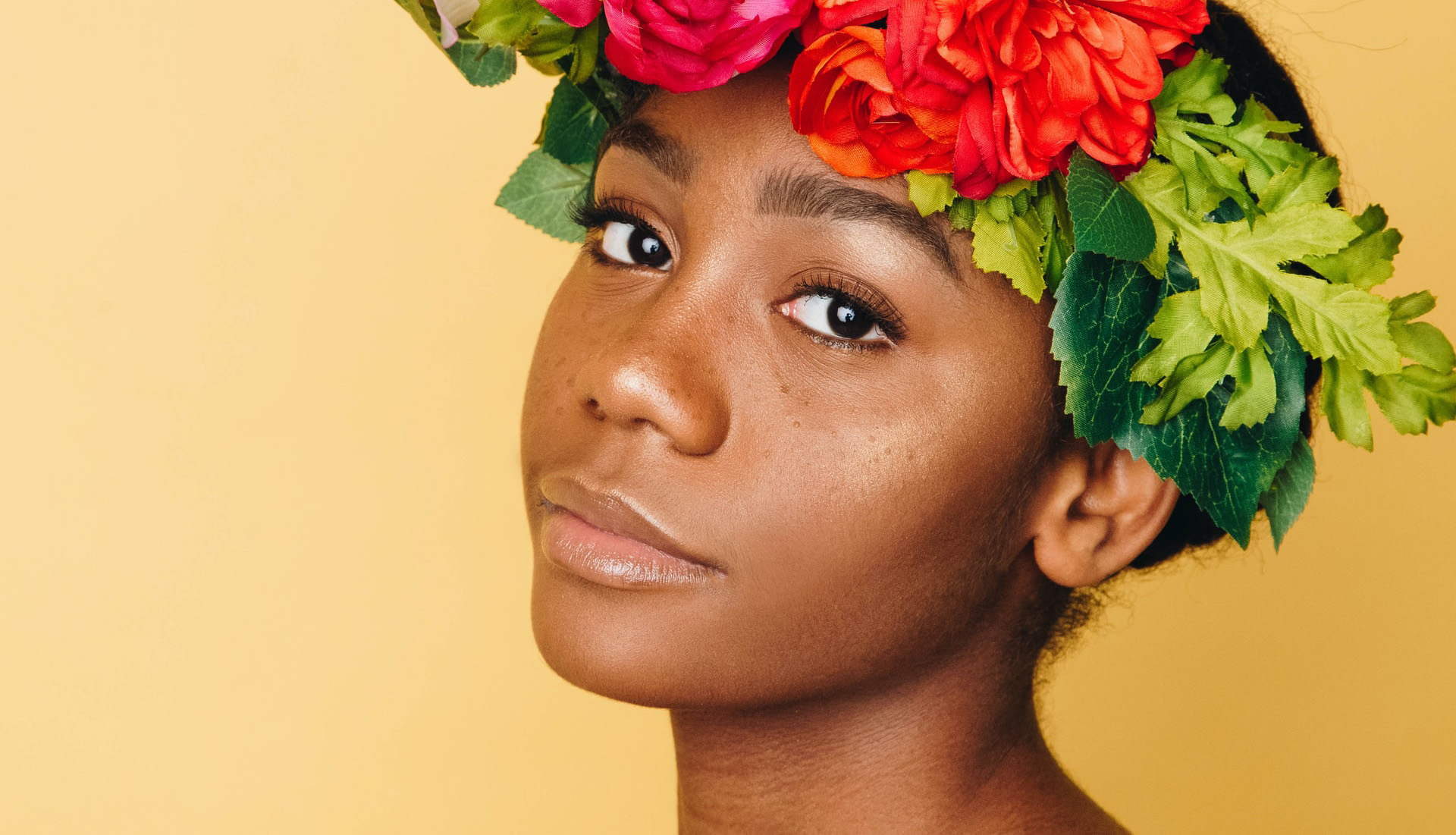 Image of person with healthy skin wearing a flower crown.