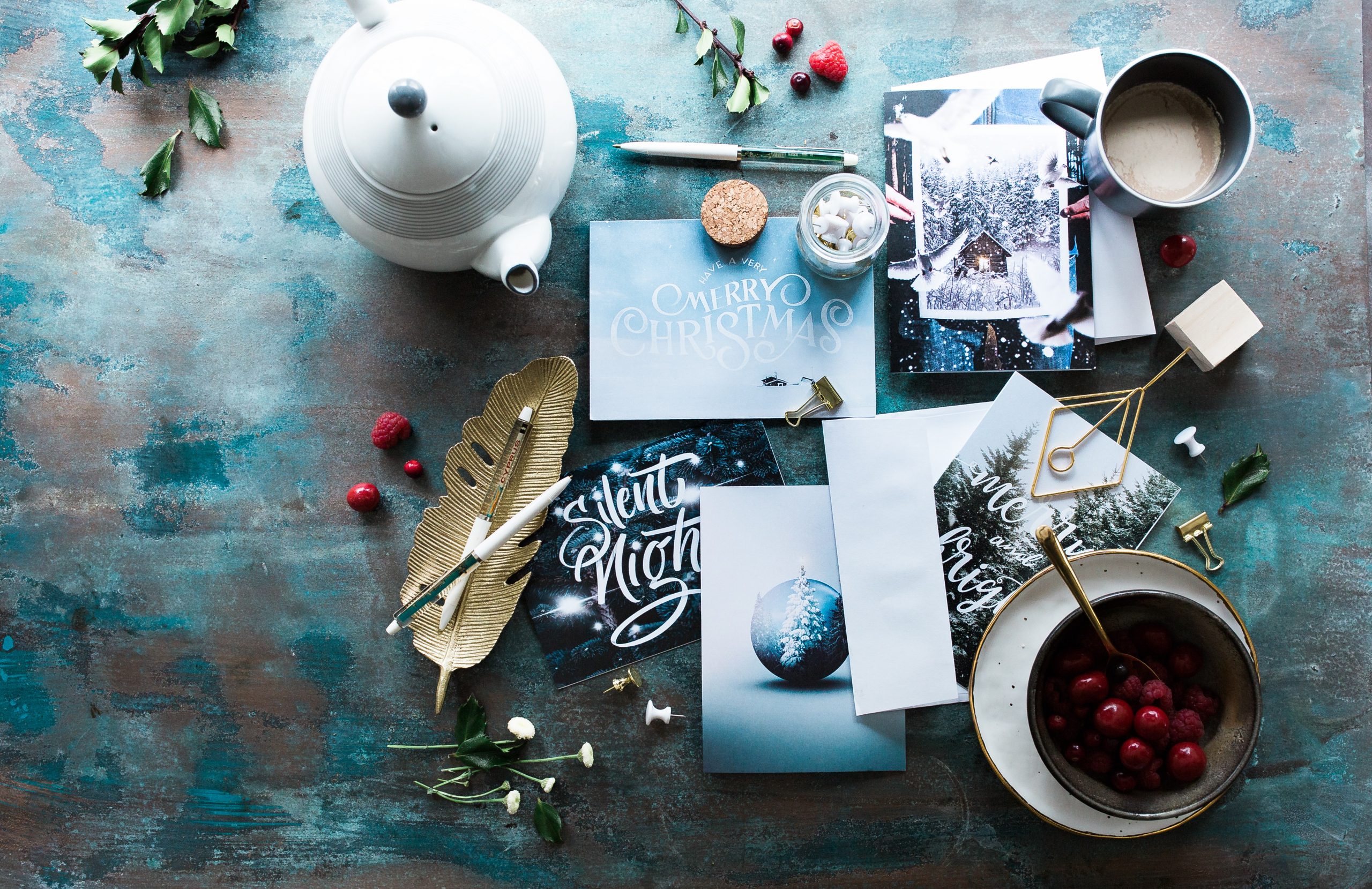 Image of holiday cards, pens and teapot with tea cup.