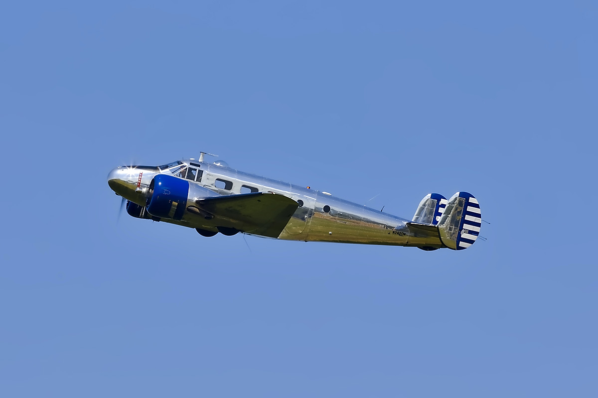 image of small silver aircraft rising before a blue sky