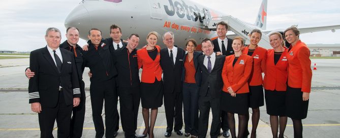 Image of a Jetstar Airways flight crew with a 787 Dreamliner behind them.