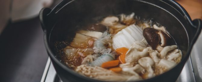 Image of a steaming pot of soup on a stove.
